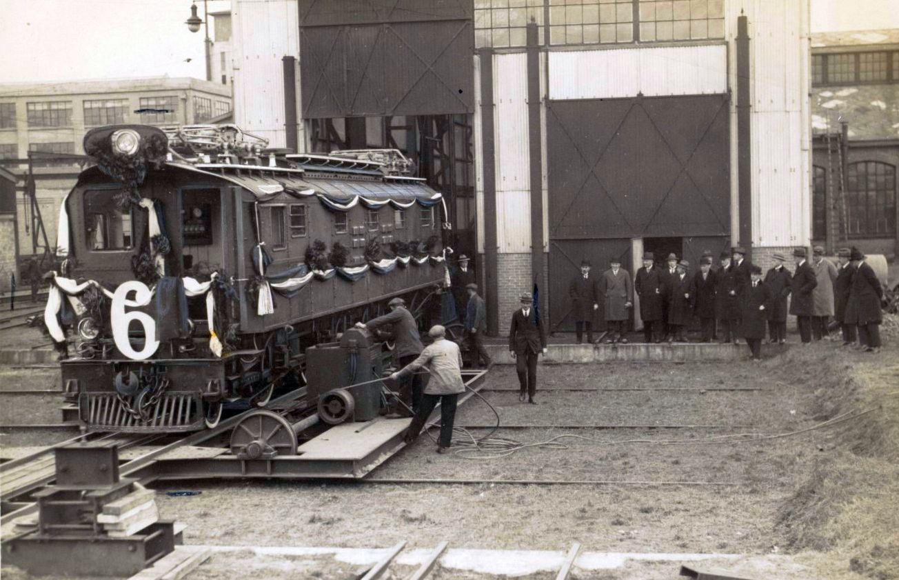 1928-Minister van Koloniën J. Ch. Koningsberger bezoekt de Heemaf. Het gezelschap bij de locomotief op het proefterrein van de Heemaf